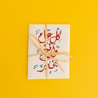 بطاقة تهنئة مع ظرف بعبارة "كل عام وأنتم بخير" مصممة باللون الأحمر وزخرفة الخط العربي - صغير
