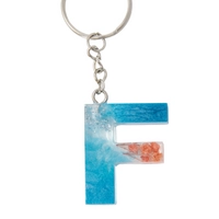 Resin Keychain with Blue Glitter and Peach Fried Flowers in the Shape of the Letter F