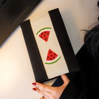 An elegant notebook with hand embroidery featuring a drawing of two watermelon pieces!