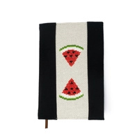 An elegant notebook with hand embroidery featuring a drawing of two watermelon pieces!