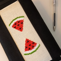 An elegant notebook with hand embroidery featuring a drawing of two watermelon pieces!