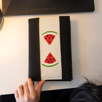 An elegant notebook with hand embroidery featuring a drawing of two watermelon pieces!