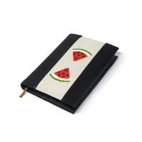 An elegant notebook with hand embroidery featuring a drawing of two watermelon pieces!