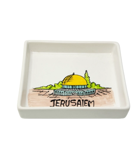 A square white dish decorated with an elaborate hand-painted drawing of the city of Jerusalem and the Dome of the Rock