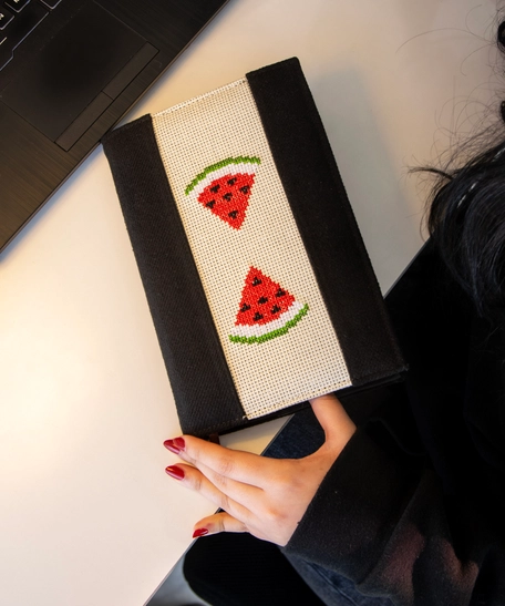 An elegant notebook with hand embroidery featuring a drawing of two watermelon pieces!