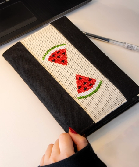 An elegant notebook with hand embroidery featuring a drawing of two watermelon pieces!