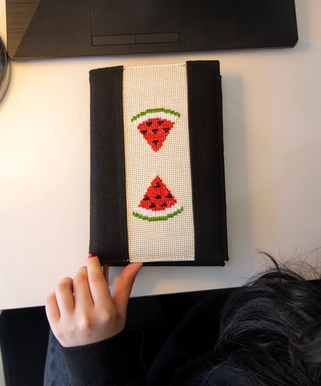 An elegant notebook with hand embroidery featuring a drawing of two watermelon pieces!